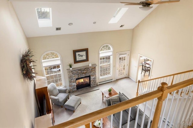 living area featuring visible vents, baseboard heating, a healthy amount of sunlight, and a skylight