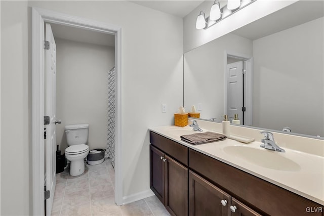 bathroom with double vanity, toilet, a sink, and tile patterned floors