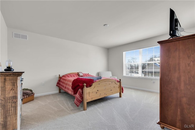 bedroom featuring baseboards, visible vents, and light colored carpet