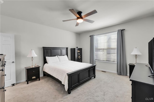 bedroom featuring light carpet, ceiling fan, visible vents, and baseboards