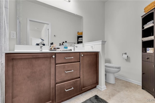 full bath with double vanity, tile patterned flooring, toilet, and baseboards