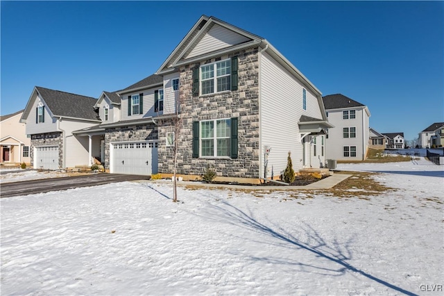 view of front of property featuring aphalt driveway, an attached garage, central air condition unit, stone siding, and a residential view