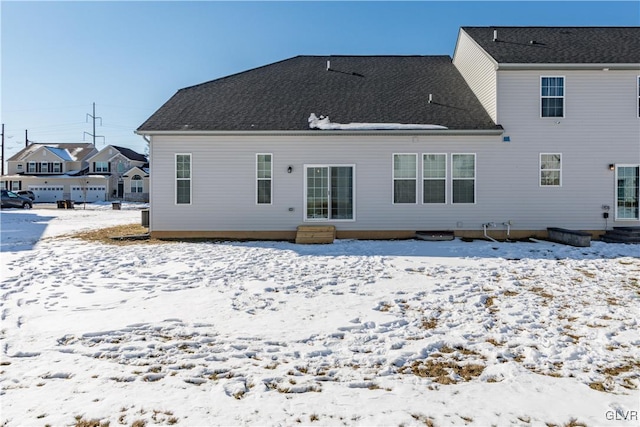 snow covered house with entry steps and roof with shingles