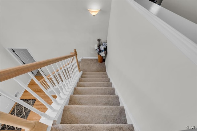 staircase featuring visible vents and baseboards