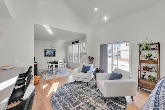 living room with high vaulted ceiling, plenty of natural light, and light wood-style flooring