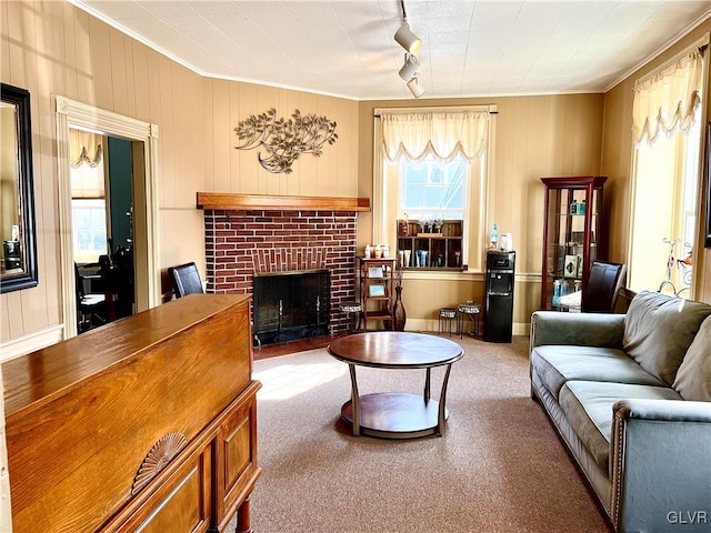 living room with carpet, a brick fireplace, crown molding, and track lighting