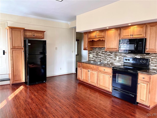 kitchen featuring a sink, backsplash, black appliances, dark wood finished floors, and crown molding