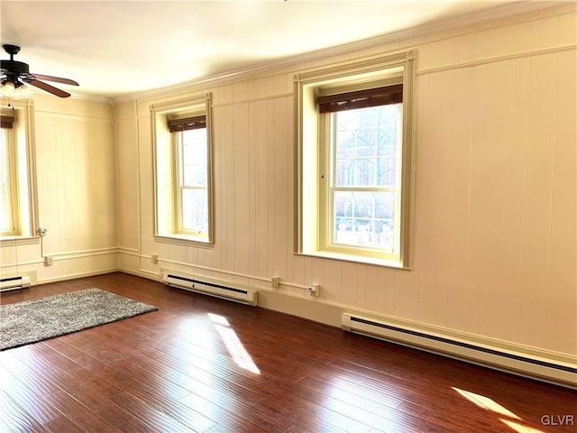 spare room featuring dark wood-style floors, a baseboard radiator, and ceiling fan