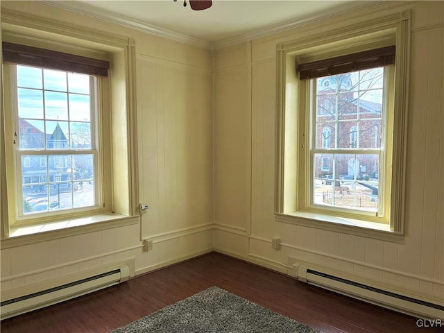 spare room featuring ornamental molding, a baseboard radiator, dark wood finished floors, and ceiling fan