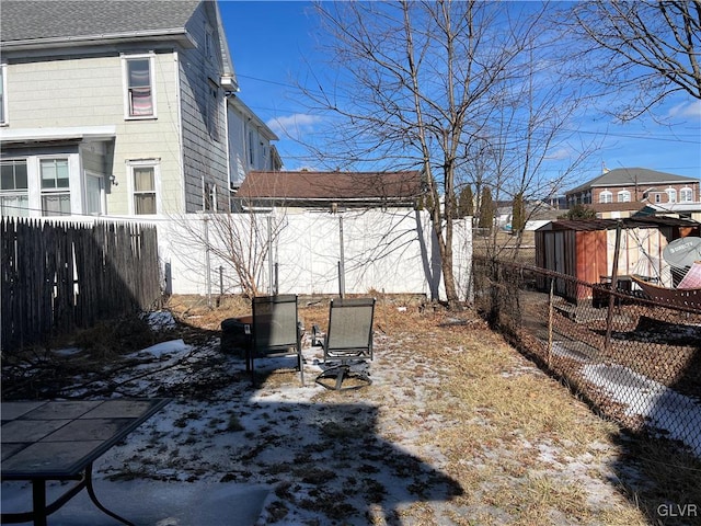 snowy yard with a fenced backyard