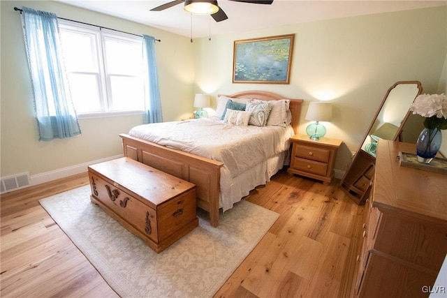 bedroom with light wood finished floors, a ceiling fan, visible vents, and baseboards