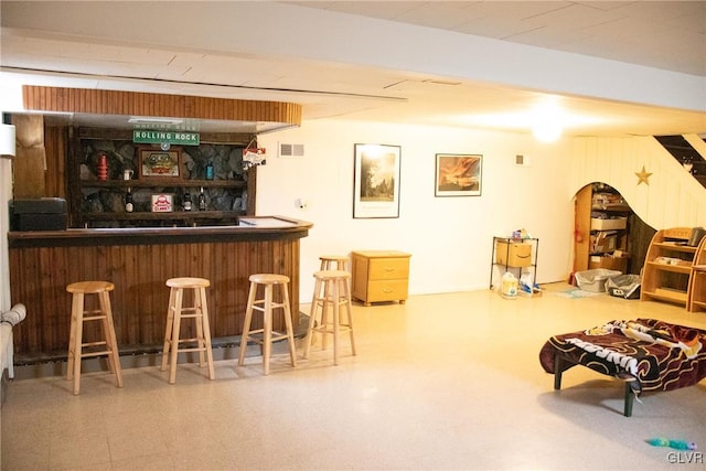 bar featuring a dry bar, visible vents, and tile patterned floors