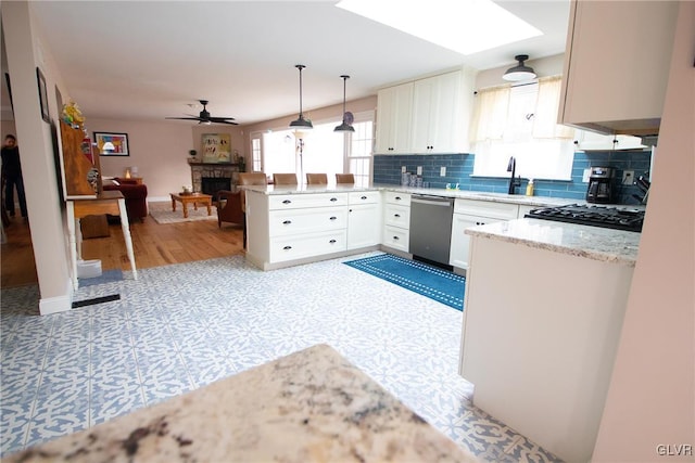 kitchen with pendant lighting, stainless steel dishwasher, open floor plan, white cabinetry, and a peninsula