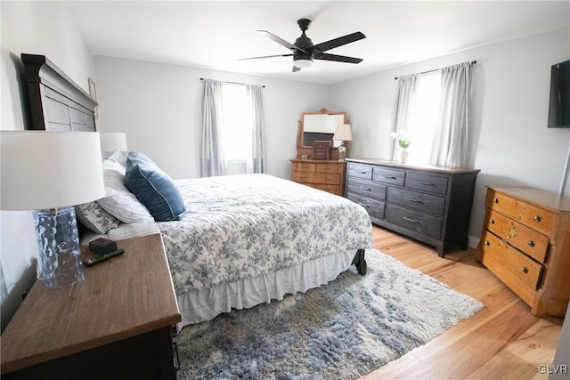 bedroom with a ceiling fan, light wood-type flooring, and multiple windows