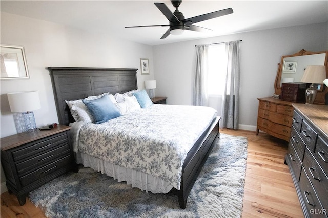 bedroom with light wood-style flooring, baseboards, and ceiling fan