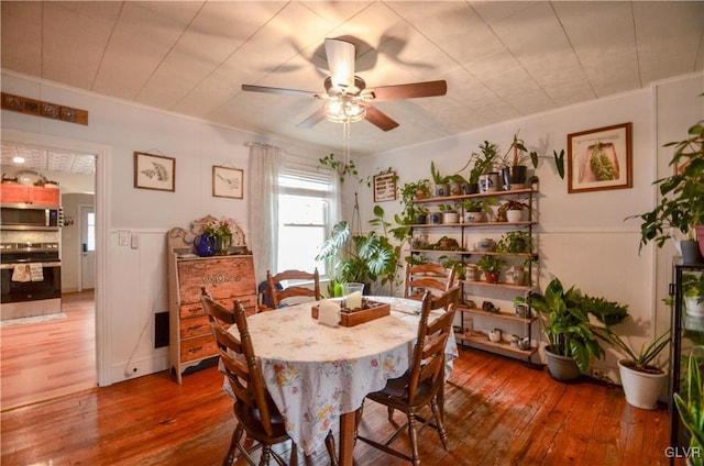 dining space featuring wood-type flooring and ceiling fan