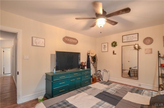 bedroom featuring wood finished floors, a ceiling fan, and baseboards