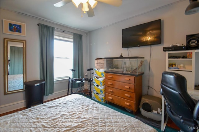 bedroom with ceiling fan and baseboards