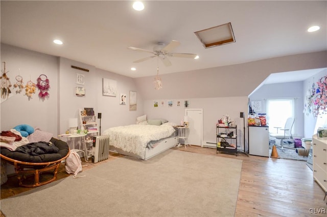 bedroom with attic access, a baseboard radiator, light wood-style flooring, and recessed lighting