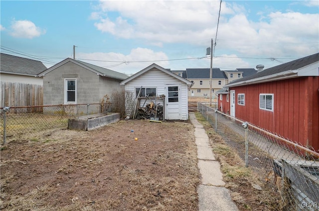 rear view of property with a fenced backyard and a garden