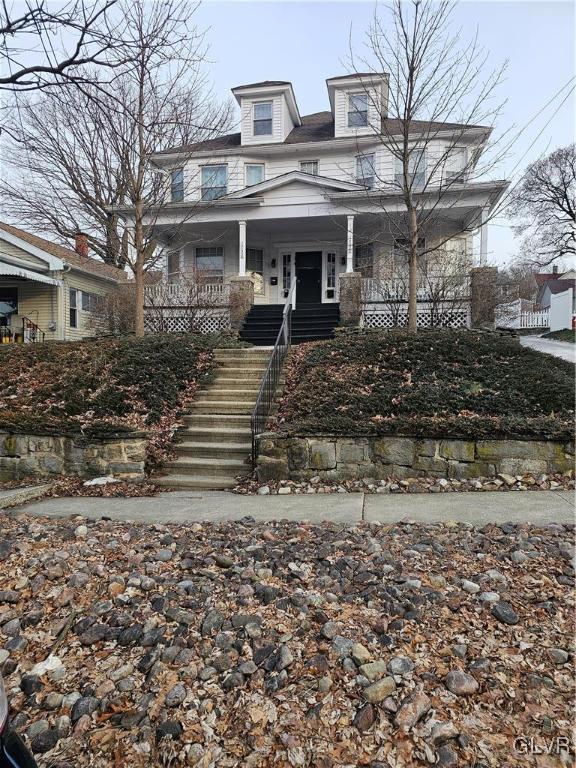 view of front of home with covered porch and stairs