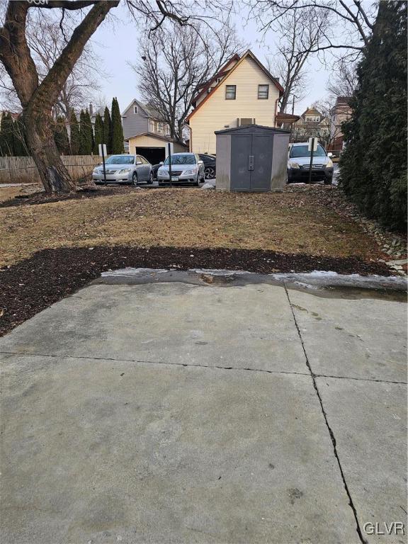 view of yard with a storage shed, fence, and an outdoor structure