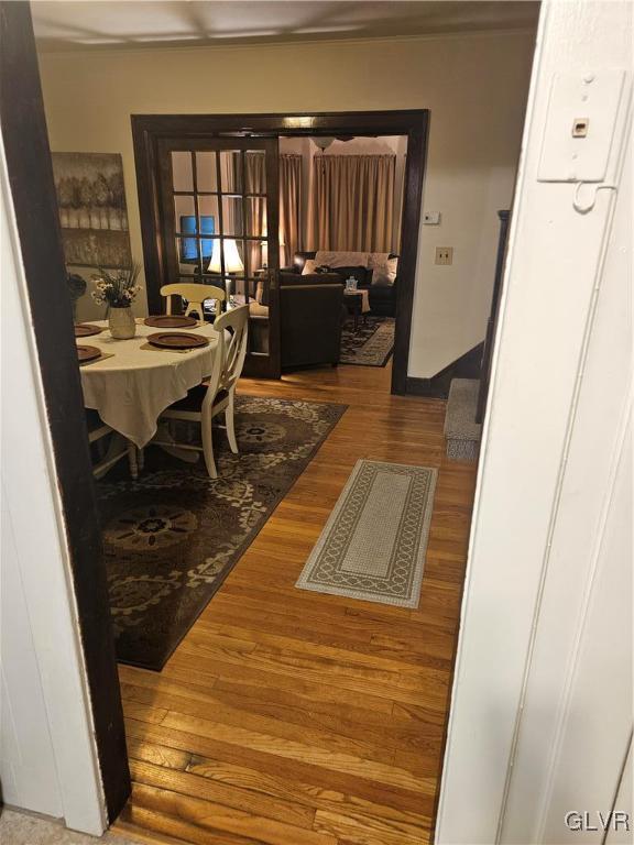 hallway featuring baseboards and wood finished floors