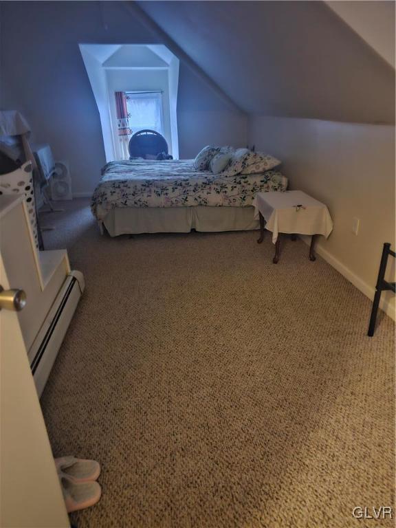 carpeted bedroom featuring baseboards, a baseboard heating unit, and vaulted ceiling