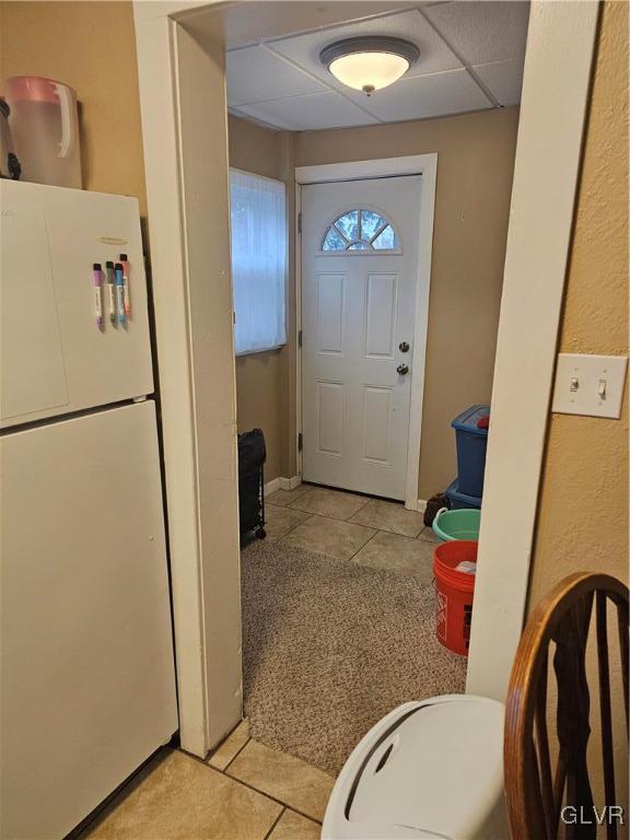 entryway featuring light tile patterned floors and a drop ceiling