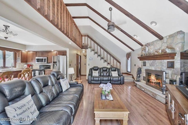 134 Moseywood Rd, Kidder Township S, PA 18624 - living room featuring high vaulted ceiling, light wood finished floors, stairway, a stone fireplace, and beam ceiling