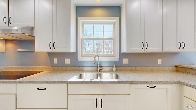 kitchen with white cabinetry, a sink, under cabinet range hood, and black electric cooktop