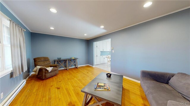 living area with light wood-type flooring, a baseboard radiator, ornamental molding, and baseboards