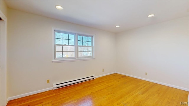 empty room featuring light wood-type flooring, a baseboard radiator, baseboards, and recessed lighting