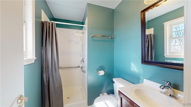 full bathroom featuring a stall shower, vanity, and toilet