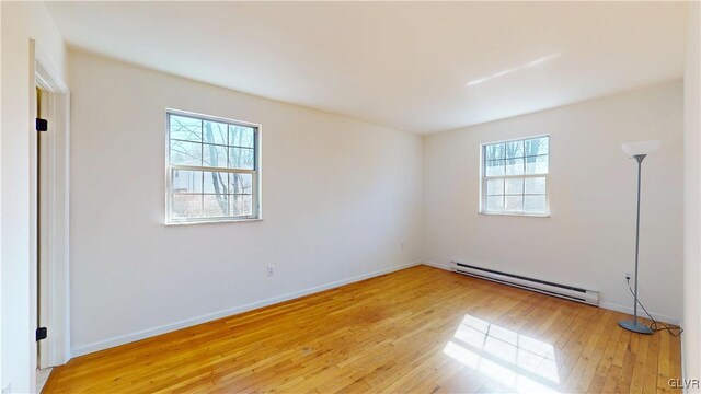 unfurnished room with light wood finished floors, a baseboard radiator, and baseboards