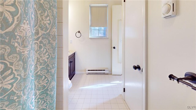 full bath featuring baseboard heating, vanity, and tile patterned floors