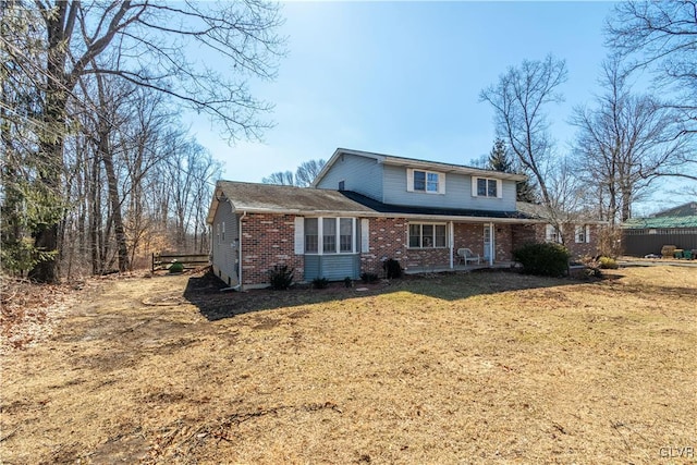 traditional home with brick siding and a front lawn