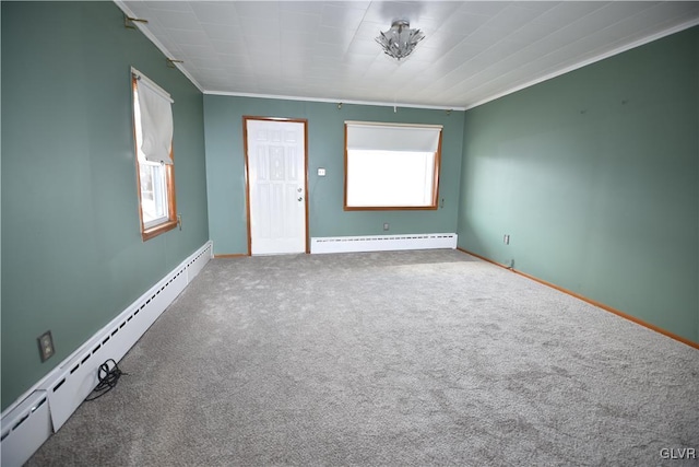 carpeted empty room with baseboards, baseboard heating, and crown molding