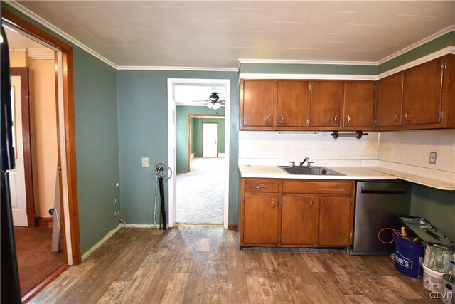 kitchen featuring brown cabinets, dark wood finished floors, a sink, and light countertops