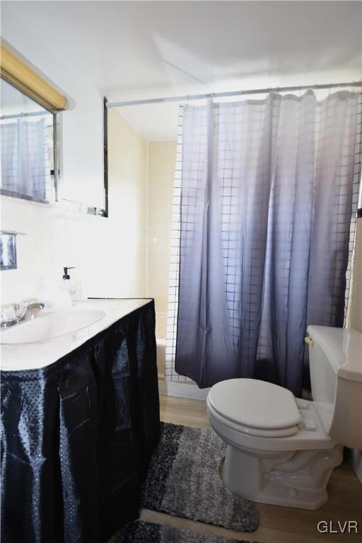 bathroom with wood finished floors, vanity, and toilet