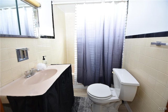 full bath with a shower with curtain, tile walls, toilet, and vanity