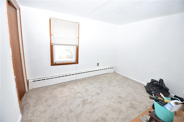 spare room with a baseboard heating unit and carpet floors