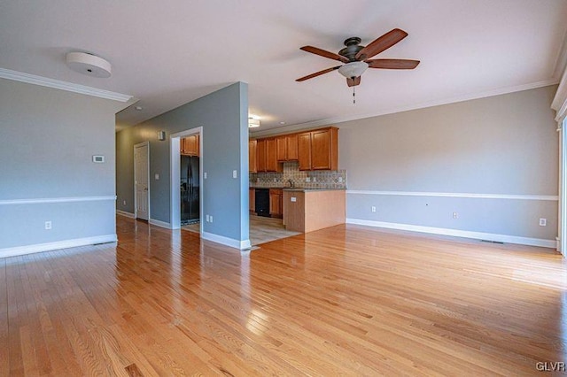 unfurnished living room with light wood-style flooring, ornamental molding, ceiling fan, and baseboards