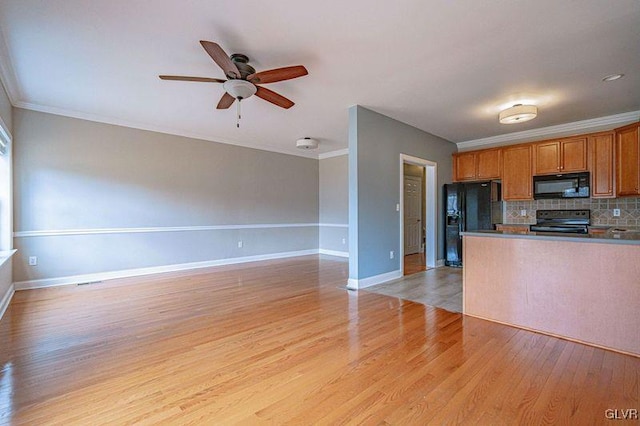 kitchen with decorative backsplash, light wood-style floors, brown cabinetry, open floor plan, and black appliances