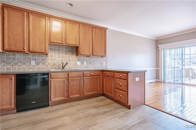 kitchen featuring a sink, a peninsula, brown cabinetry, and dishwasher