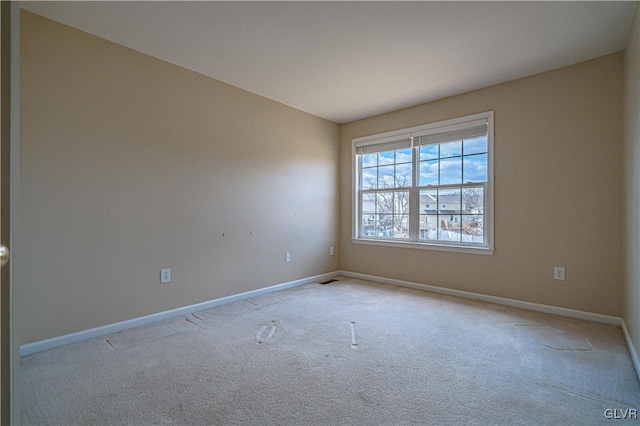 empty room featuring carpet floors and baseboards