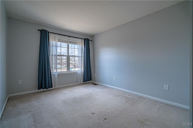 unfurnished room with carpet floors, visible vents, and baseboards