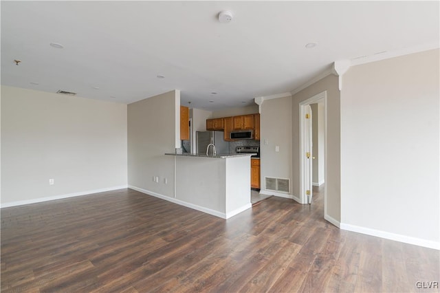 kitchen featuring brown cabinetry, stainless steel appliances, dark wood-style flooring, and open floor plan