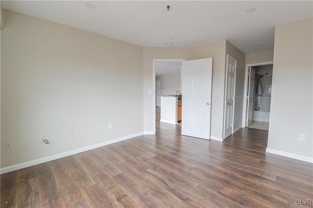 empty room featuring dark wood finished floors and baseboards