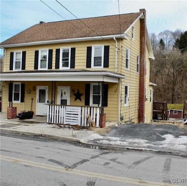 view of front of home with covered porch and roof with shingles